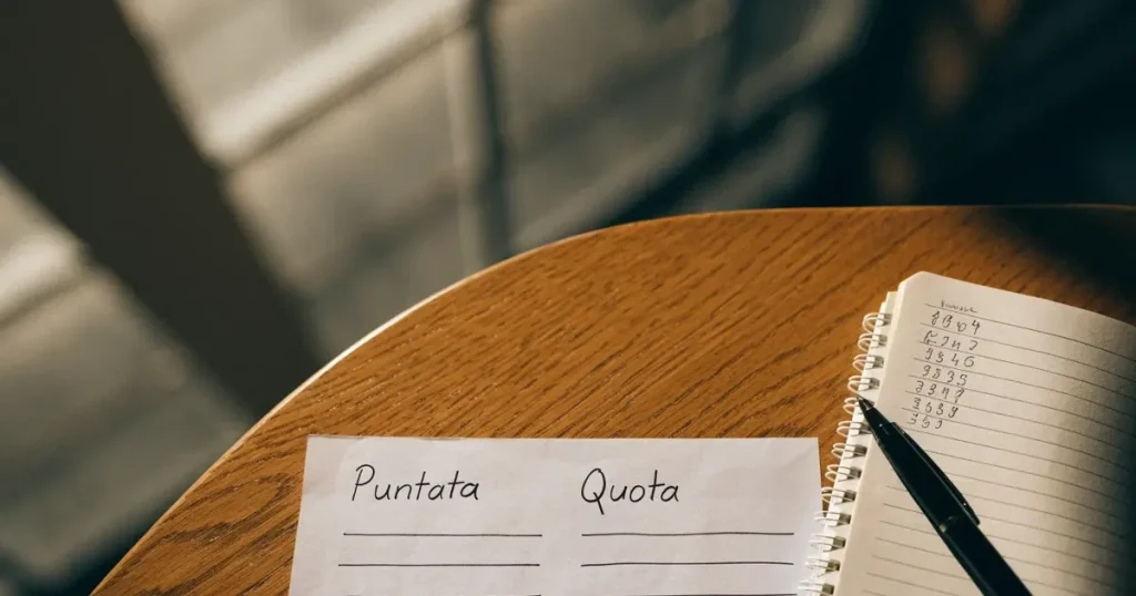Una schedina bianca accanto a una calcolatrice e a un blocco di appunti con uno schema disegnato a mano